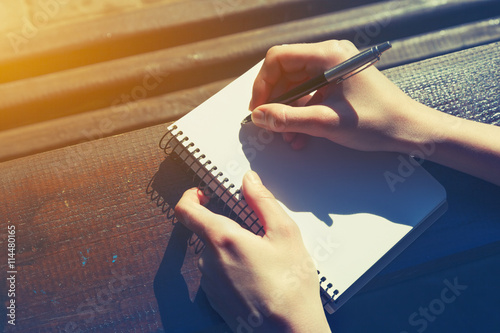 girls hand writing with pen on wooden desk