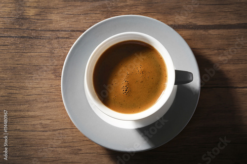 Cup of fresh coffee on wooden background