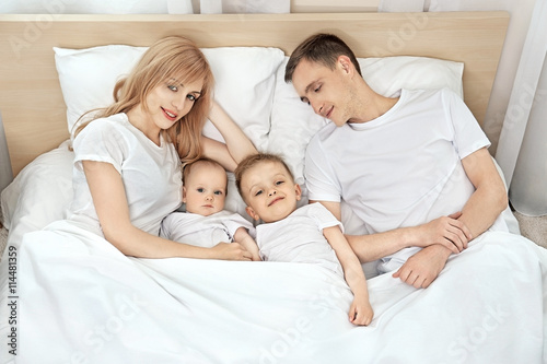 Happy family on white bed i...