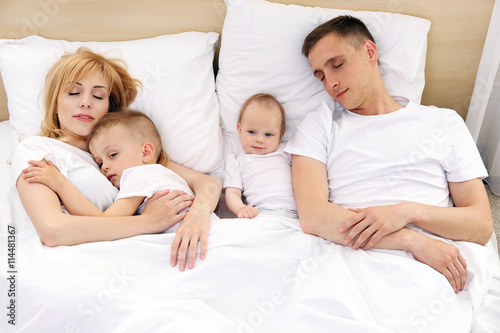 Happy family on white bed i...
