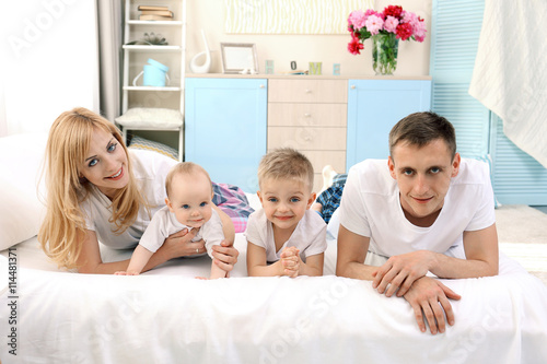 Happy family on white bed i...