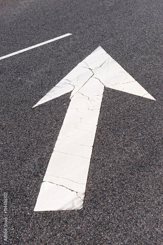 directional arrow sign painted on road surface