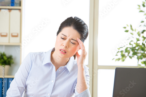 Young asian business woman with headache