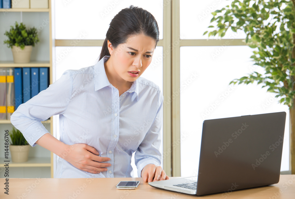 Young asian business woman with stomachache Young asian business woman with stomachache