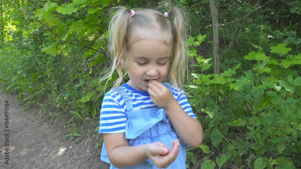 Little girl eating strawberries in the woods. Little girl eating strawberries in the woods.