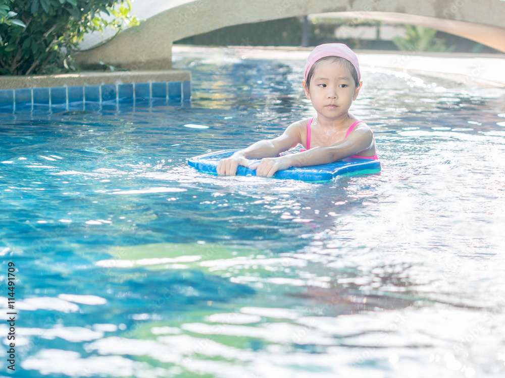 Asian girl is playing in the pool, sun set light