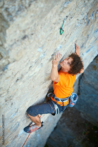 male rock climber. rock climber climbs on a rocky wall. man makes hard move