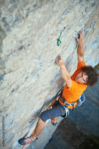 male rock climber. rock climber climbs on a rocky wall. focus on the hand