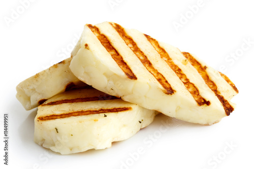 Three grilled slices of halloumi cheese isolated on white in perspective. With grill marks.