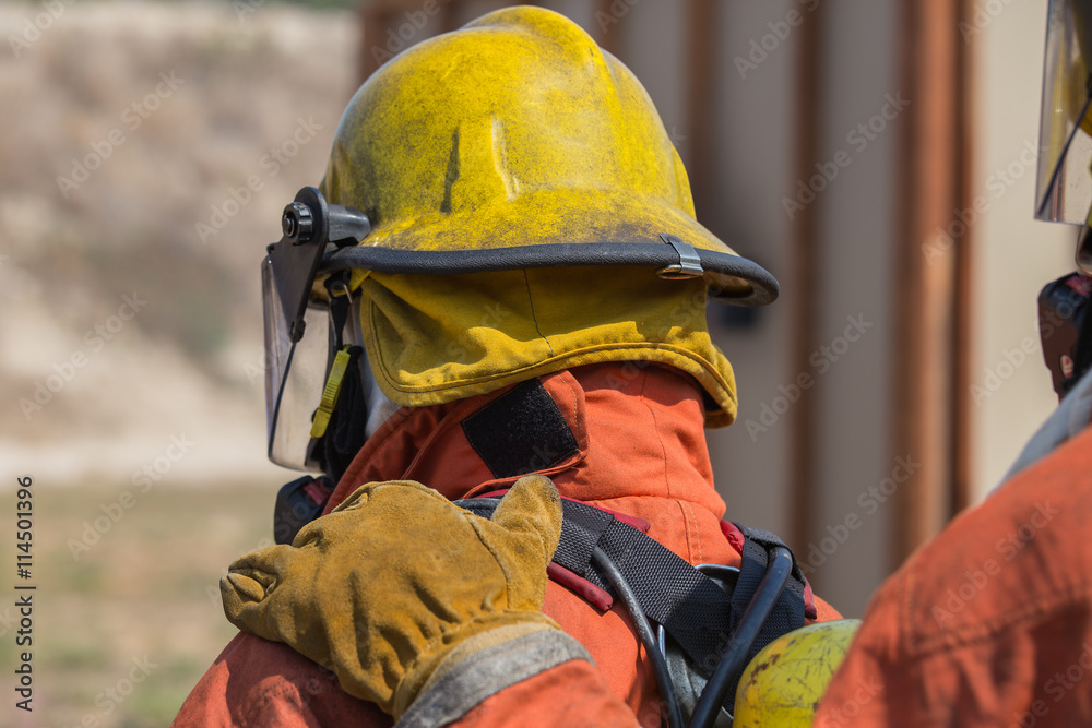 Fototapeta premium firefighter hand put on shoulder of first man for signal in fire