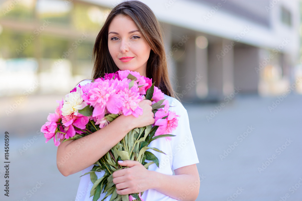 Fototapeta premium Stylish woman with flowers peonies outdoors