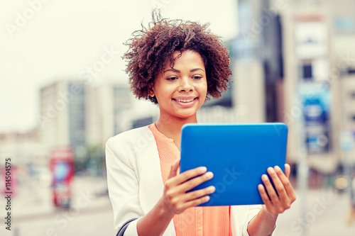 happy african businesswoman with tablet pc in city