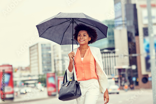 happy african american businesswoman with umbrella