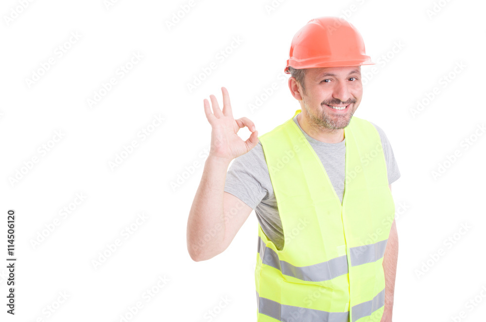 Joyful builder wearing vest and helmet showing ok Joyful builder wearing vest and helmet showing ok