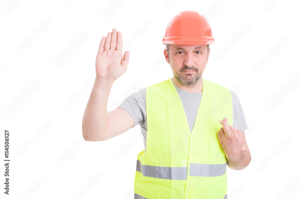 Serious builder rising his right hand and swearing false Serious builder rising his right hand and swearing false