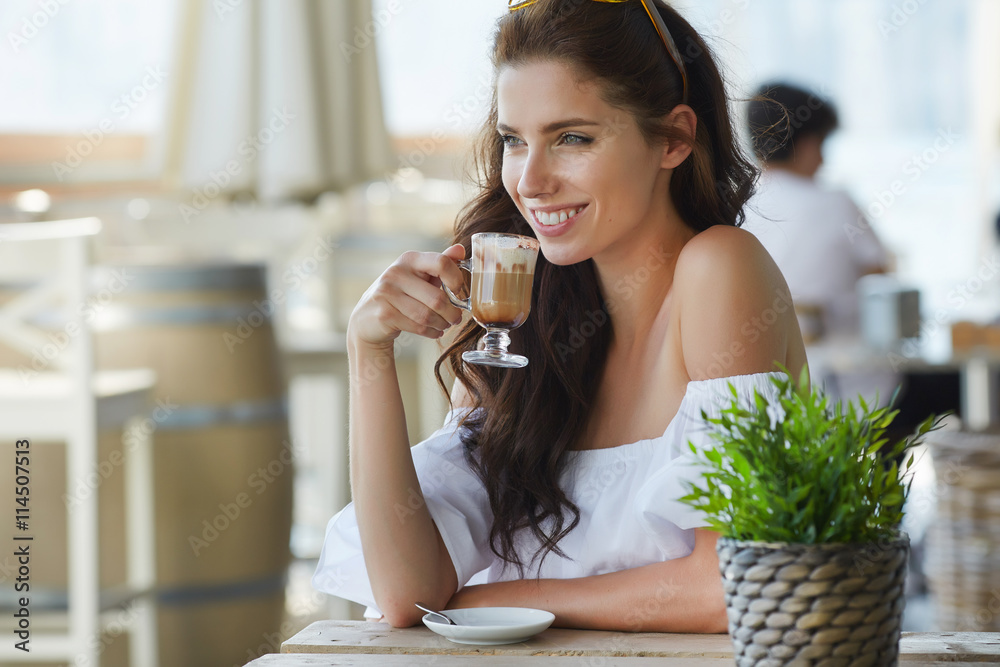 Obraz premium Portrait of beautiful blond woman sitting in outdoors cafe in It