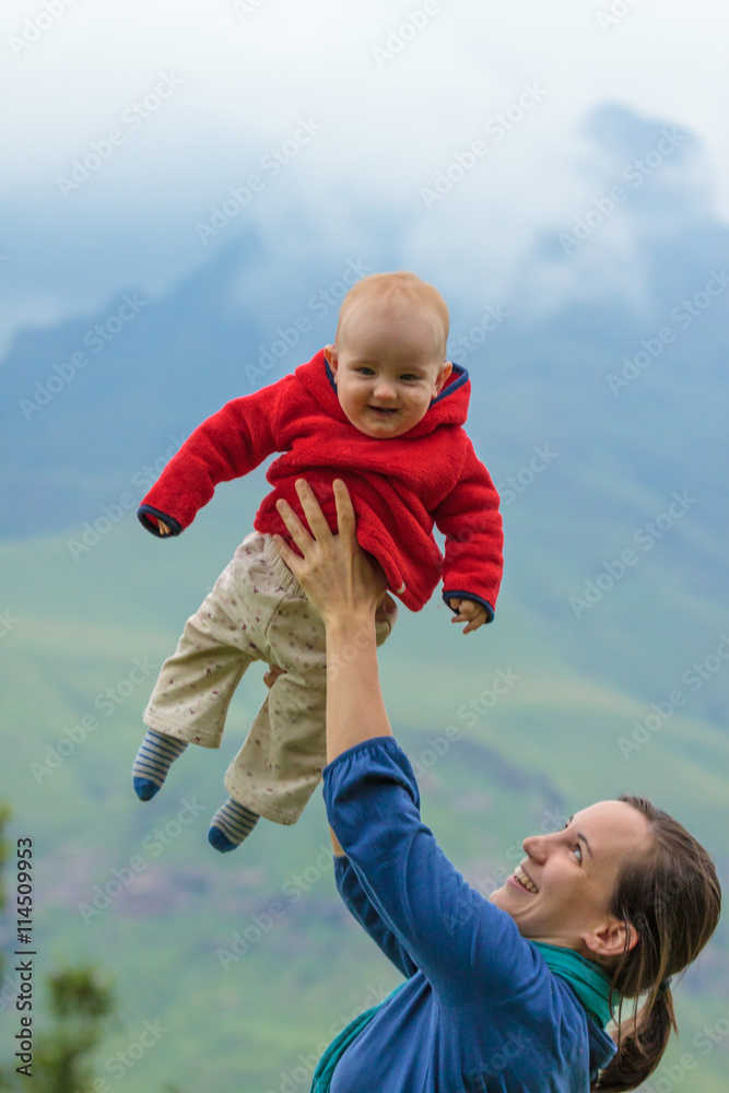 Fototapeta premium Mutter wirft Baby in die Luft