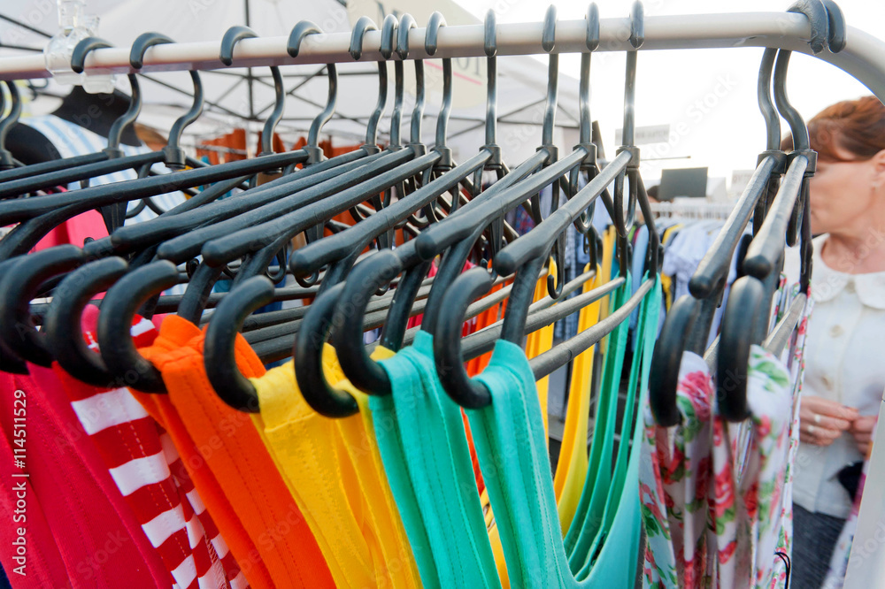 Female clothes on hangers inside fashion store