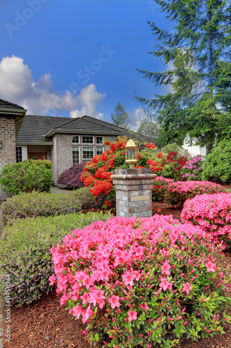 Luxury house exterior with brick trim, tile roof and french windows.