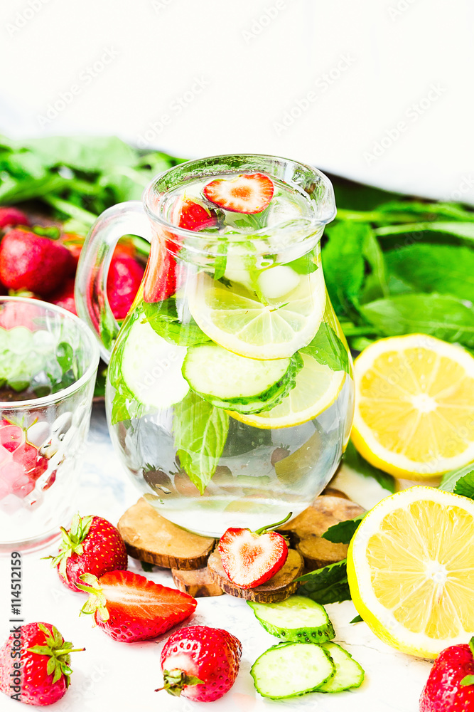 water-detox with lemon, strawberries and mint on light backgroun water-detox with lemon, strawberries and mint on light backgroun