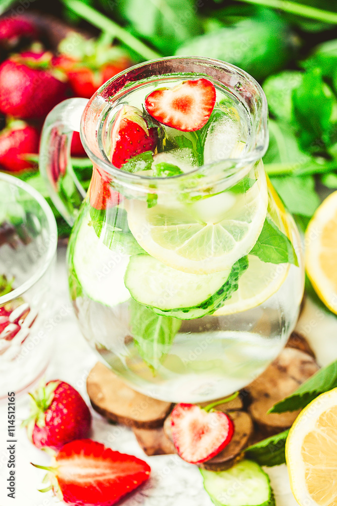 water-detox with lemon, strawberries and mint on light backgroun water-detox with lemon, strawberries and mint on light backgroun