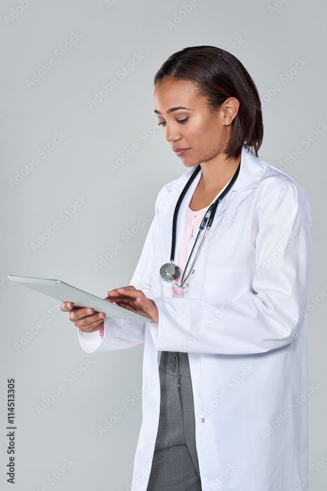 Professional female doctor in lab coat and sethoscope using elec Professional female doctor in lab coat and sethoscope using elec