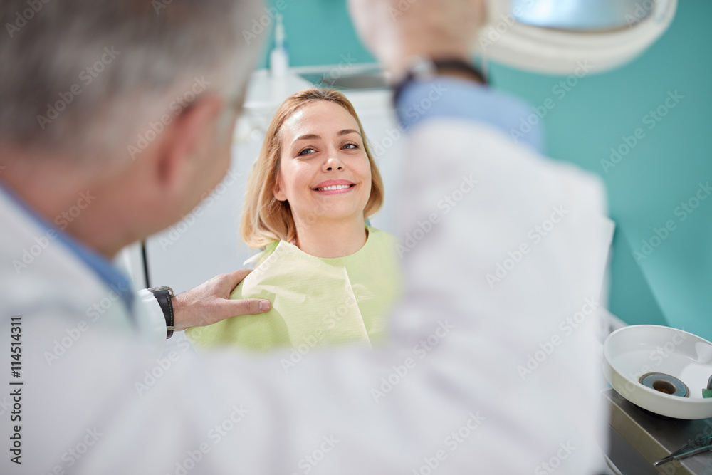 Nice female patient smiling in dental chair Nice female patient smiling in dental chair