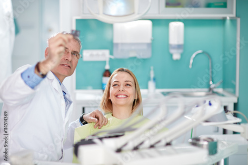 Smiling female woman with dentist looking at dental snapshot