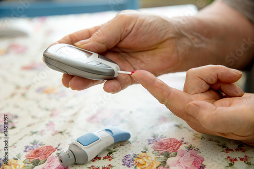 Senior woman is checking her sugar level with glucometer. In 2013 it was estimated that over 382 million people throughout the world had diabetes.