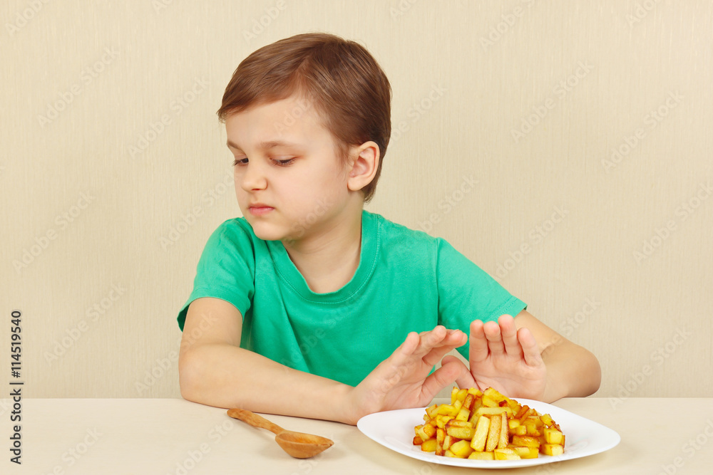 Little cute boy refuses to eat a french fries Little cute boy refuses to eat a french fries