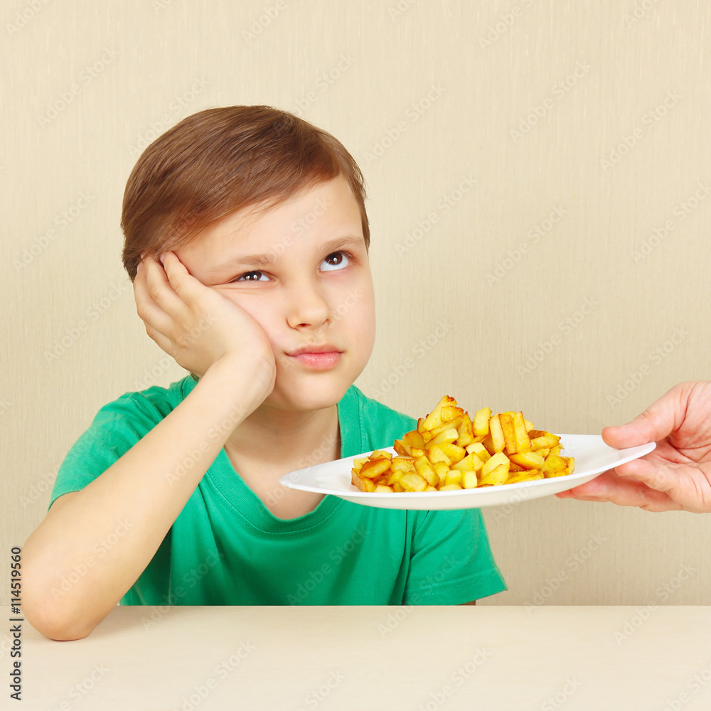 Little cute boy refuses to eat a fried potatoes Little cute boy refuses to eat a fried potatoes