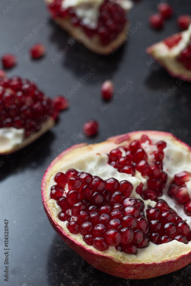 Red juicy pomegranate on dark marble background. Healthy, antioxidant, fresh, gourmet, delicious, organic fruit. Ingredient for grenadine. Close-up and copy space. Red juicy pomegranate on dark marble background. Healthy, antioxidant, fresh, gourmet, delicious, organic fruit. Ingredient for grenadine. Close-up and copy space.