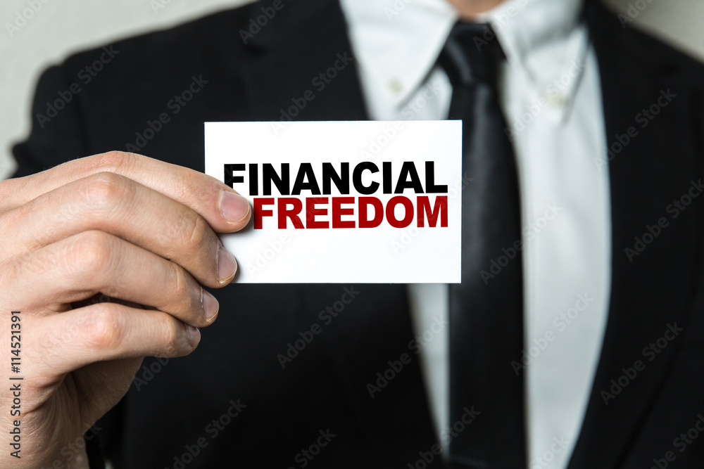 Business man holding a card with the text: Financial Freedom