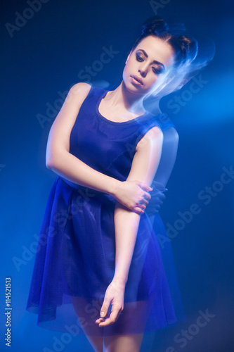 Woman in blue dress with hairstyle and make-up