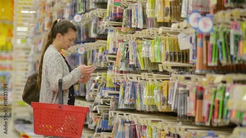 young beautiful woman buying stationery for school, beautiful mother choose pens and tools in a supermarket for her children