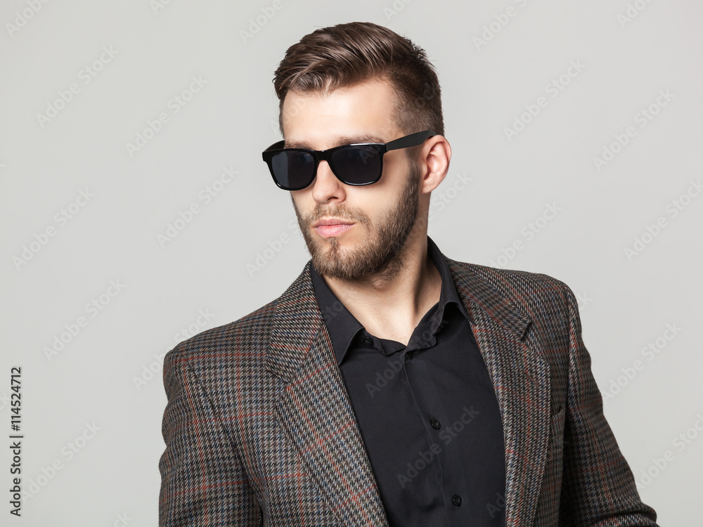Studio portrait of handsome elegant young man in brown jacket po Studio portrait of handsome elegant young man in brown jacket po