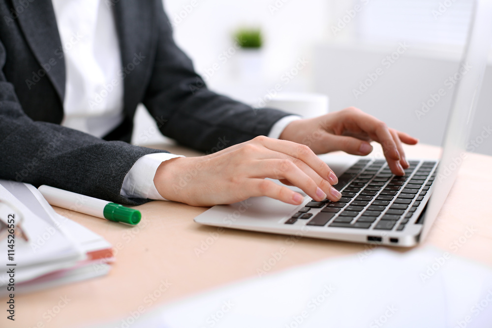 Close up of business woman hands typing on laptop computer in the white colored office. Close up of business woman hands typing on laptop computer in the white colored office.