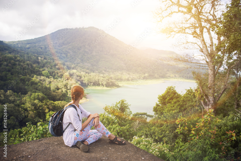 Fototapeta premium Woman looking on sunset,view on Bayan lake,Bali,Indonesia