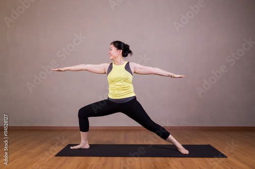 Female performing the Warrior 2 or Virabhadrasana 2 yoga pose photo