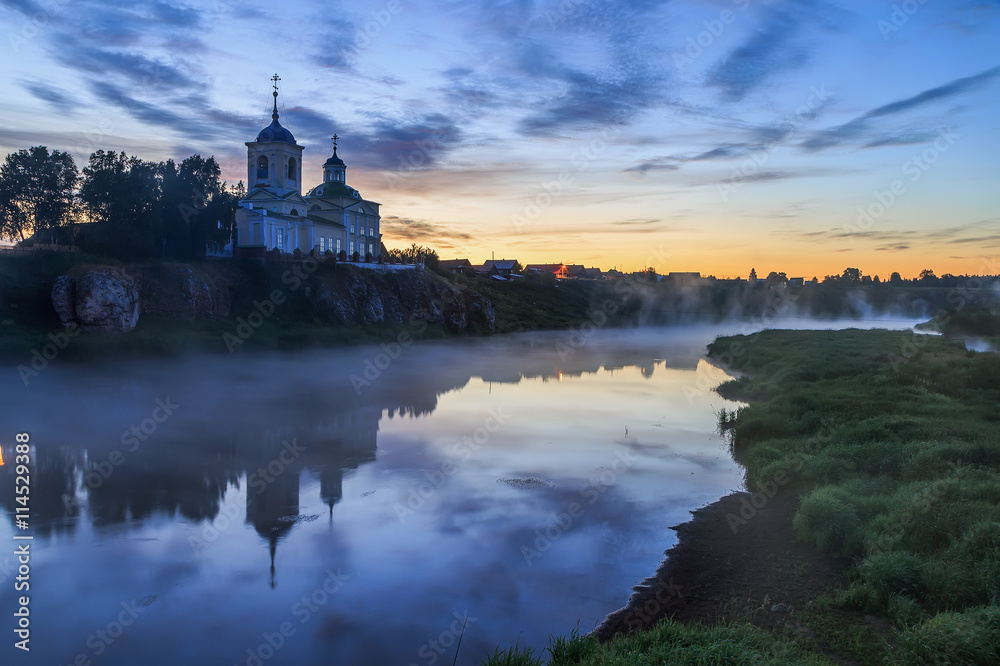 Russian orthodox monastery. Fog over the river near the cliff and church. Ural, Chusovaya.