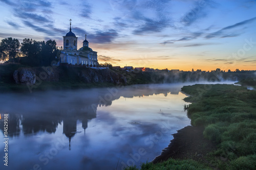 Russian orthodox monastery. Fog over the river near the cliff and church. Ural, Chusovaya.