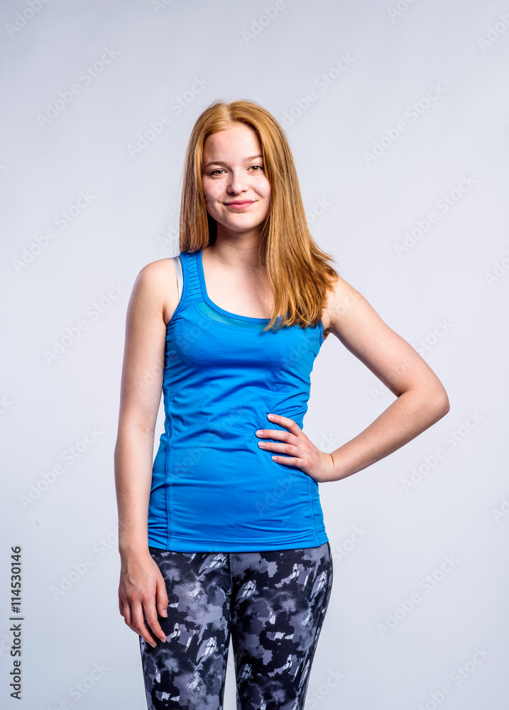 Girl in blue singlet and fitness leggings, young woman, studio s Girl in blue singlet and fitness leggings, young woman, studio s