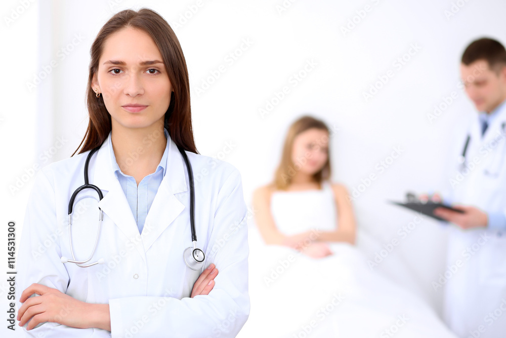Friendly female doctor on the background with patient in the bed and his doctor Friendly female doctor on the background with patient in the bed and his doctor