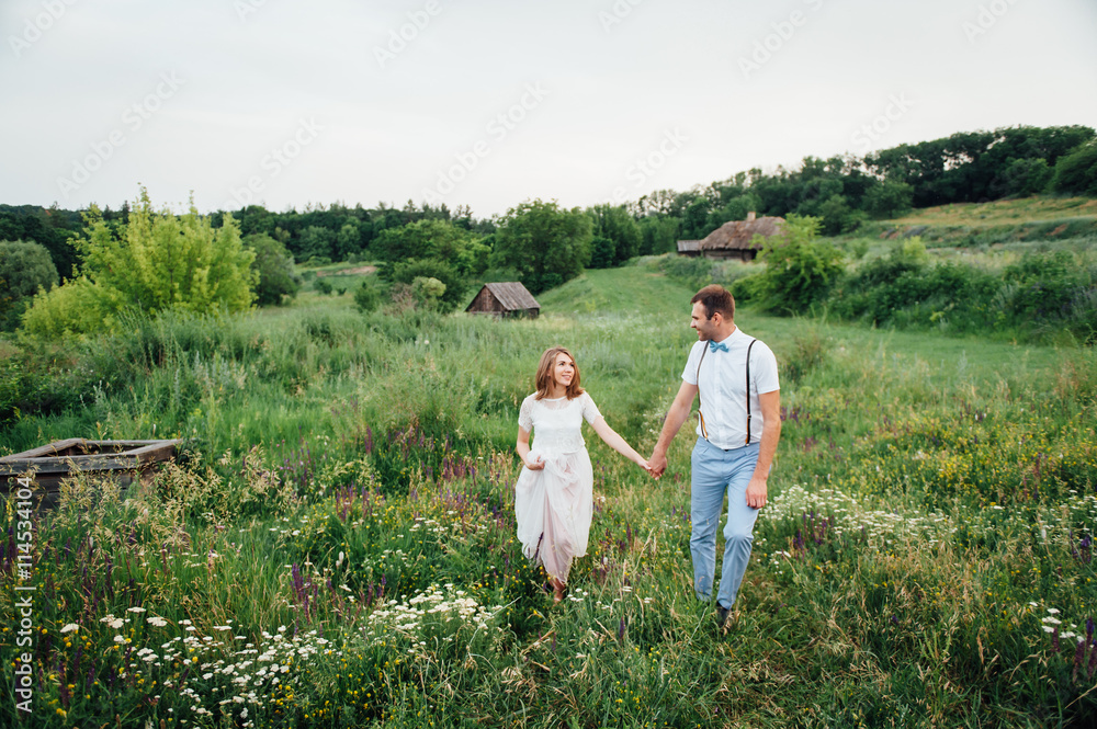 Happy Bride and groom walking on the green grass Happy Bride and groom walking on the green grass