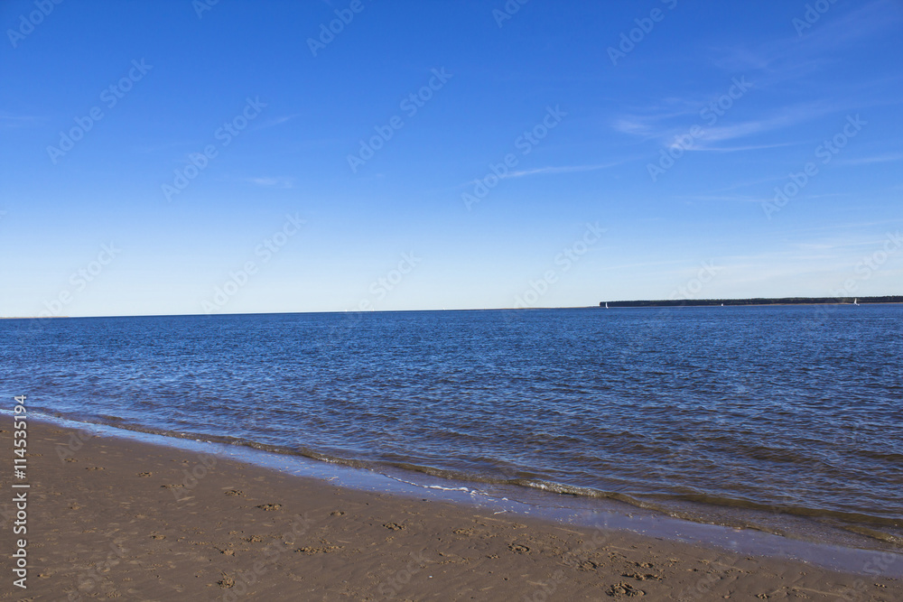 Beach in Broughty Ferry, Dundee, Scotland. Beautiful blue sky and sailboats on the horizon.