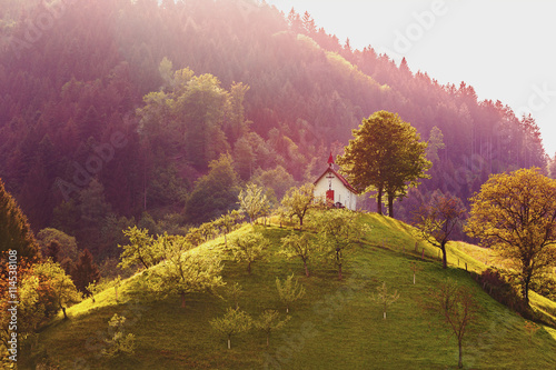 Scenic mountain landscape with a church at sunset. Germany, Black Forest.