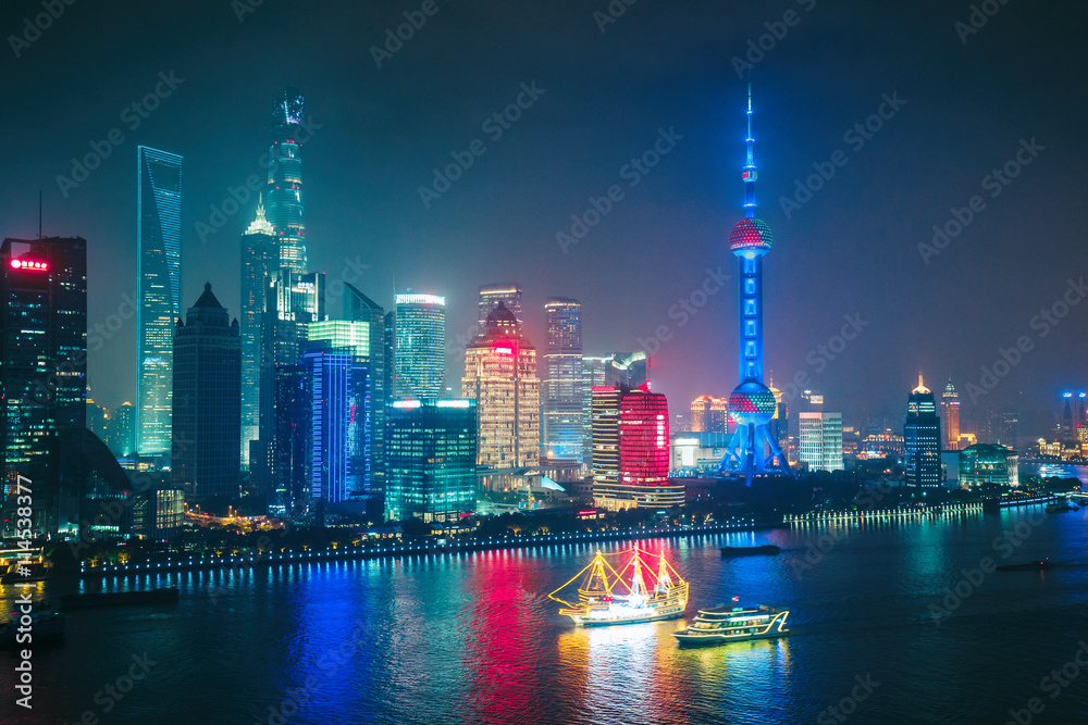 Fototapeta premium Widok z lotu ptaka na duże, nowoczesne miasto nocą. Szanghai Chiny. Nocna panorama z oświetlonymi wieżowcami.