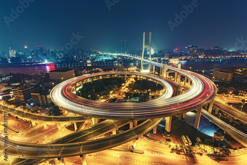 View over the Nanpu Bridge in Shanghai, China with car trails. Fantastic nighttime urban skyline. photo