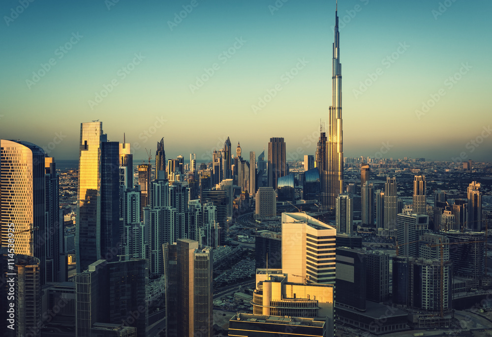 Downtown Dubai with many modern skyscrapers. Aerial view over the famous architecture of Dubai at sunset.