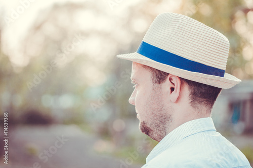 Man in white hat is looking forward. Toned photo. Outdoor.